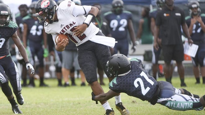 Palm Beach Central quarterback Anarjahe Douriet (12) is brought down by Atlantic free safety Jacques Jonas (21) during the first half of the game between Palm Beach Central and Atlantic at Atlantic High School in Delray Beach, Fla., on Saturday, August 25, 2018.