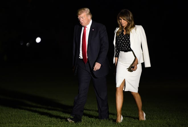 President Donald Trump and first lady Melania Trump walk across the South Lawn of the White House in Washington, Friday, Aug. 24, 2018, after returning from a trip to Columbus, Ohio. (AP Photo/Susan Walsh)