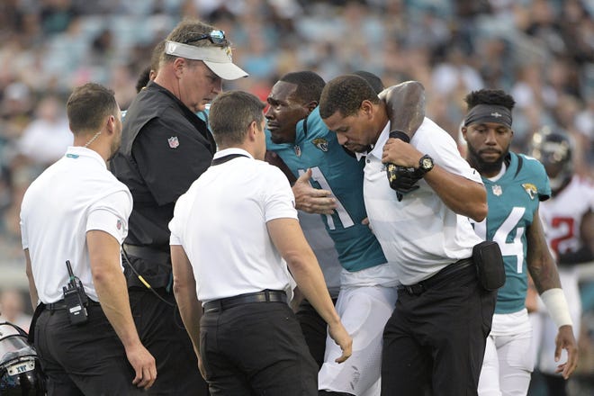 Jacksonville Jaguars head coach Doug Marrone, second from left, consoles wide receiver Marqise Lee (11) as members of the training staff help him to an awaiting cart after being hit on a pass play during the first half of an NFL preseason football game against the Atlanta Falcons Saturday, Aug. 25, 2018, in Jacksonville, Fla. (AP Photo/Phelan M. Ebenhack)