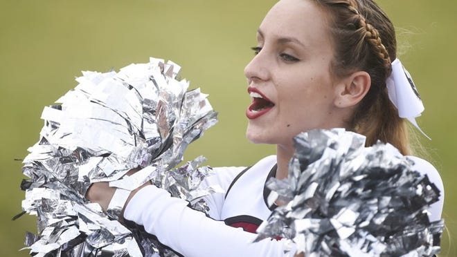 Palm Beach Central student Ashley Jacob, 15, performs a cheer with pompoms during the game between Palm Beach Central and Atlantic at Atlantic High School in Delray Beach on Saturday. Eight days after a shooting at Palm Beach Central's campus during a high school football game. Ashley is back on the field performing as a member of the cheer team.