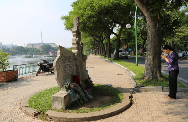 A woman pays respect at the monument of the late U.S. Senator John McCain in Hanoi, Vietnam, Monday, Aug. 27, 2018. The monument was erected by Vietnamese authority to mark the day when McCain's plane, a Major in the U.S. Navy was shot down in 1967. Vietnam has been paying respect to McCain who died on Saturday. (AP Photo/Tran Van Minh)