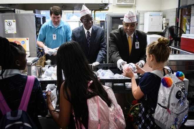 Cumberland County Superintendent Marvin Connelly Jr., right, and Spring Lake Mayor Larry Dobbins, center, serve breakfast to students at Lillian Black Elementary School on Monday in Spring Lake. [Andrew Craft/The Fayetteville Observer]