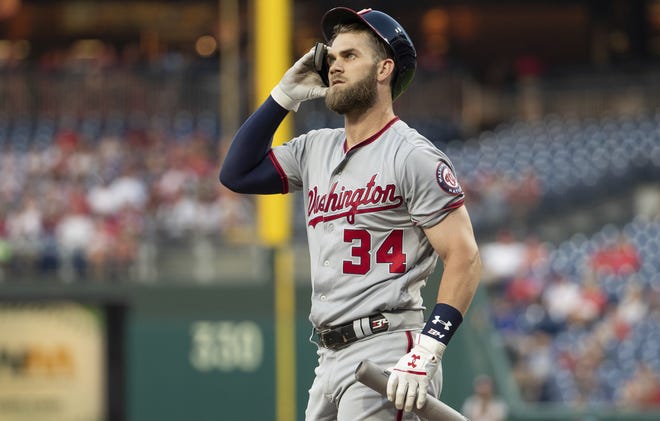 The Nationals' Bryce Harper heads back to the dugout after striking out against Aaron Nola of the Phillies in the first inning Tuesday night. [CHRIS SZAGOLA/ASSOCIATED PRESS]