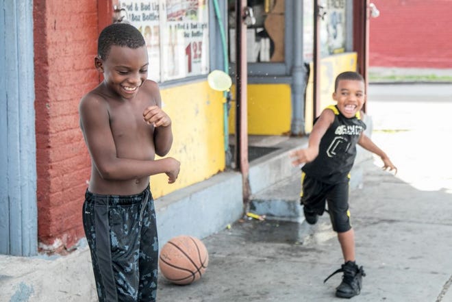 Zidon Barnes, left, and his cousin Zephon Barnes, right, try to keep cool on Tuesday in the City of Newburgh by tossing water balloons at each other.