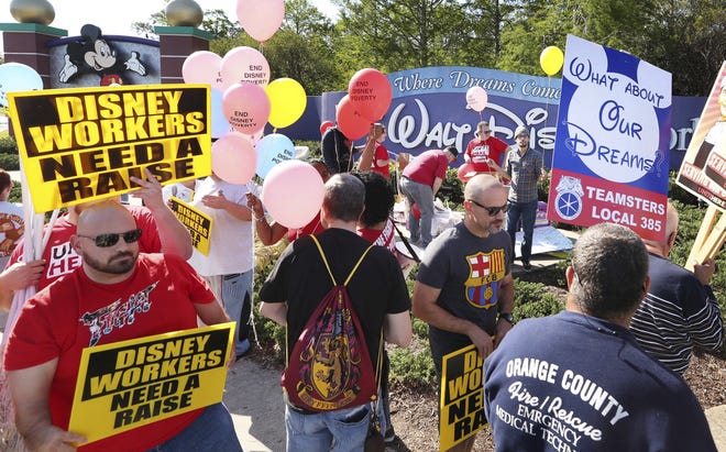 In this March 23, 2018, file photo, unionized workers for Walt Disney World and their supporters march and chant in front of Disney hotel property in Orlando. [AP FILE PHOTO]