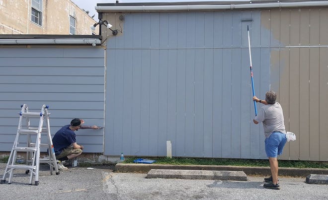 Jonny Gonzalez and Jack Scott worked under the blazing sun Monday afternoon to paint the exterior of Waynesboro Community and Human Services on Walnut Street. ANDREA ROSE/THE RECORD HERALD