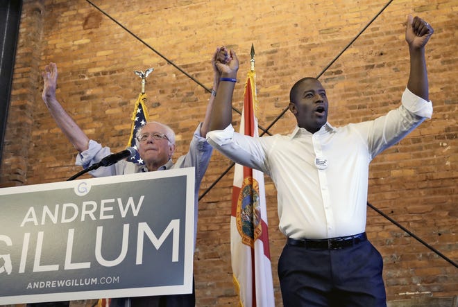 U.S. Sen. Bernie Sanders, I-Vt, left, and Democratic gubernatorial hopeful Andrew Gillum hold hands during a campaign rally Aug. 17 in Tampa. The first black nominee for governor in Florida history, Gillum also is the most progressive in modern times. [AP Photo/Chris O'Meara]