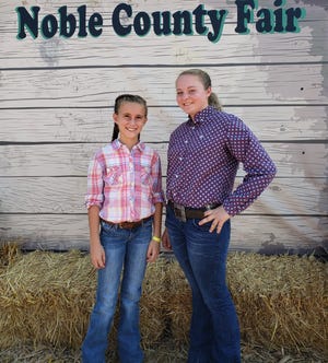 Lexi Franklin, left, and Erica Snook, right. The two girls are taking a moment away from preparing to show their goats at the Noble County Fair.