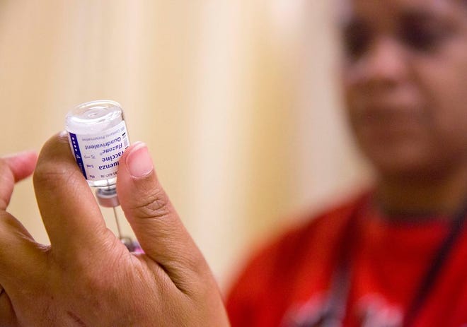 A nurse prepares a flu shot from a vaccine vial at the Salvation Army Feb. 7 in Atlanta.
