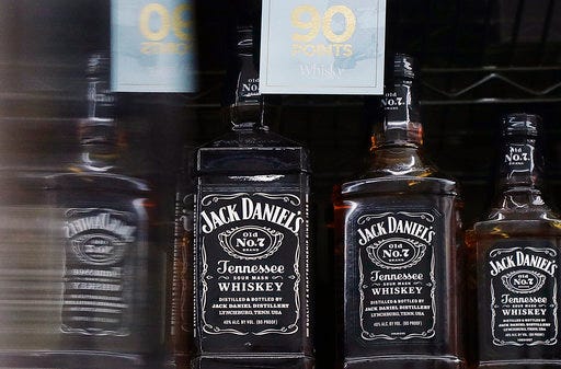 FILE- This July 9, 2018, file photo shows bottles of Jack Daniel's whiskey displayed at Rossi's Deli in San Francisco. Spirits company Brown-Forman Corp. said Wednesday, Aug. 29, that its first-quarter net income rose sharply, fueled by strong overseas sales, but the maker of Jack Daniel's Tennessee Whiskey cautioned that global trade disputes are causing "significant uncertainty." (AP Photo/Jeff Chiu, File)