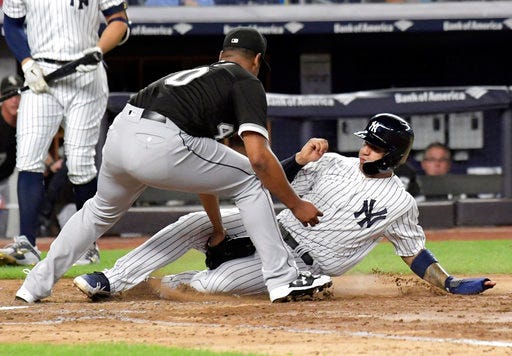Chicago White Sox pitcher Reynaldo Lopez tags out New York Yankees runner Gleyber Torres, right, attempting to score when the ball got away from catcher Kevan Smith during the fifth inning of a baseball game Wednesday, Aug. 29, 2018, at Yankee Stadium in New York. (AP Photo/Bill Kostroun)