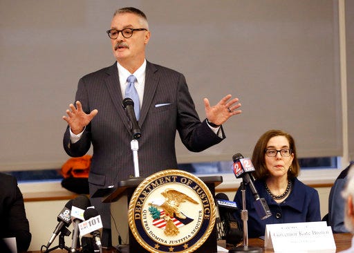 FILE - In this Feb. 2, 2018 file photo, U.S. Attorney for the District of Oregon Billy J. Williams, left, speaks at a marijuana summit in Portland, Ore., as Oregon Gov. Kate Brown sits at right. Federal prosecutors in Oregon have charged six people with running two 'vast' interstate trafficking operations that they say delivered marijuana grown in Oregon to Texas, Virginia and Florida. Williams said Wednesday, Aug. 29, 2018, that proceeds from the black market sales returned to Oregon as cash stuffed in airplane luggage or through the U.S. mail. (AP Photo/Don Ryan, File)