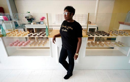 In this Friday, Aug. 24, 2018, photo Patrice Farooq poses for a photo inside the new location of her Cupcake Kitchen Houston bakery in Houston. Farooq's previous store was damaged by water from Hurricane Harvey. She lost an estimated $30,000 in equipment and inventory. Even as she was first dealing with the damage, Farooq began using Facebook ads to let customers know she'd be reopening, and to ensure they didn't forget about her shop. (AP Photo/David J. Phillip)