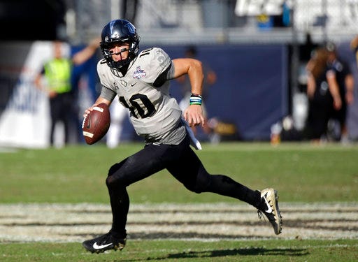 FILE - In this Dec. 2, 2017, file photo, Central Florida quarterback McKenzie Milton scrambles during the second half of the American Athletic Conference championship NCAA college football game against Memphis, in Orlando, Fla. Most of the playmakers return from one of the best offenses in the country, including gifted quarterback McKenzie Milton. (AP Photo/John Raoux, File)