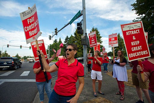 Hudson's Bay High School American sign language teacher Danna Claborn responds to support from drivers while joining fellow strikers at the corner of Fort Vancouver Way and East Mill Plain Boulevard in Vancouver, Wa. on Wednesday, Aug. 29, 2018. (Amanda Cowan/The Columbian via AP)