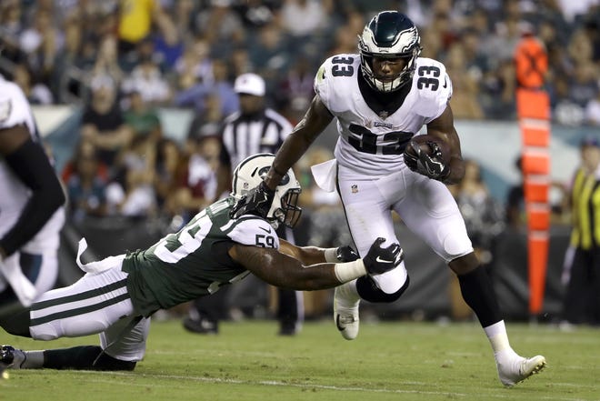The Eagles rookie running back Josh Adams tries to elude the Jets' Frankie Luvu during the first half of Thursday night's preseason finale against the Jets. [MATT ROURKE/THE ASSOCIATED PRESS]