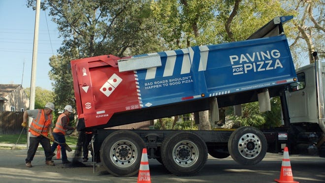Dominoís is saving pizza, one pothole at a time. Cracks, bumps, potholes and other road conditions can put good pizzas at risk after they leave the store. Now Dominoís is hoping to help smooth the ride home by asking customers to nominate their town for pothole repairs at pavingforpizza.com. (PRNewsfoto/Domino's Pizza)