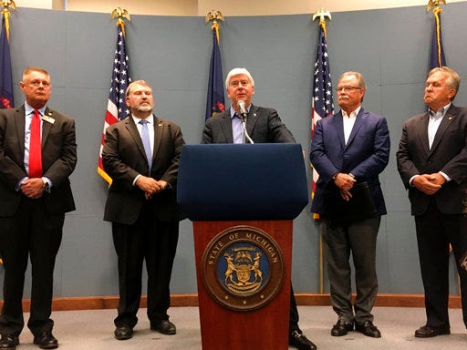 Michigan Gov. Rick Snyder announces support from the business community for his proposed fee increases to pay for environmental cleanup and water infrastructure needs on Thursday, Aug. 30, 2018, at his office in Lansing. Also pictured, from left to right, are Republican state Rep. Larry Inman, Michigan Farm Bureau President Carl Bednarski, Michigan Chamber of Commerce President and CEO Rich Studley and Republican state Sen. Mike Nofs. (AP Photo/David Eggert)