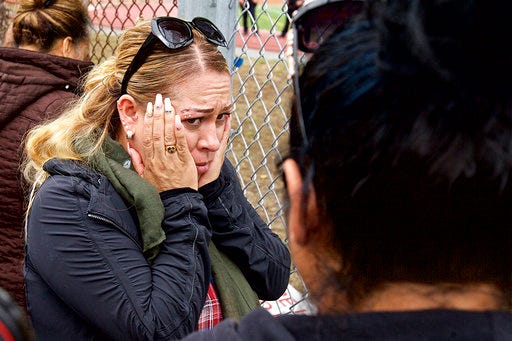 A woman gets emotional while waiting for her child to be released after a report of a shooting at Balboa High School on Thursday, Aug. 30, 2018, in San Francisco. Police said they arrested three people Thursday after responding to a report of a gunshot inside the high school. A gun was recovered on school grounds, but police spokeswoman Grace Gatapandan declined to say if it had been fired. (Kevin N. Hume/The San Francisco Examiner via AP)