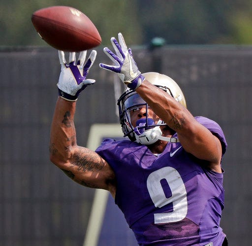 FILE - In this Aug. 10, 2018, file photo, Washington's Myles Gaskin reaches for a pass reception at NCAA college football practice, in Seattle. No. 6 Washington's potential Heisman Trophy contenders Gaskin and quarterback Jake Browning play against No. 9 Auburn in the only opening-week game between top ten teams. (AP Photo/Elaine Thompson, File)