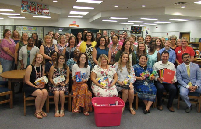 Virginia's Secretary of Education Atif Qarni, front right, visits with the staff of Patrick Copeland Elementary School in the school's library to deliver a bin of school supplies on Aug. 30, 2018. [Kate Gibson/progress-index.com]
