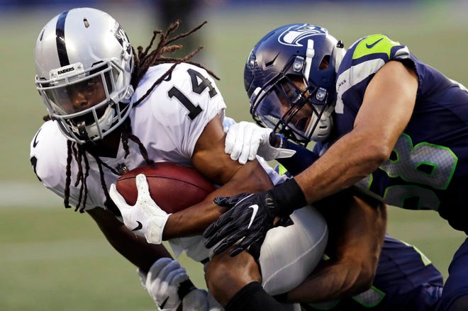 Oakland Raiders wide receiver Keon Hatcher (14) is tackled by Seattle Seahawks linebacker Austin Calitro, right, during the first half of an NFL football preseason game, Thursday, Aug. 30, 2018, in Seattle. (AP Photo/Stephen Brashear)