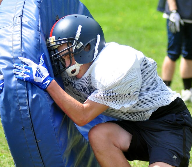 Pembroke players and hopefuls battled the tackle wheel during practice/tryouts Wed. August 22 at Pembroke High School. The Titans are looking at a number of young players to rise up and become stars. [Wicked Local Photo/William Wassersug]