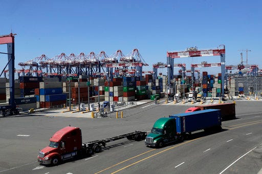 ADVANCE FOR USE FRIDAY, AUG. 31, 2018, AT 3:01 A.M. EDT AND THEREAFTER - In this Wednesday, Aug. 22, 2018, photo trucks travel along a loading dock at the Port of Long Beach in Long Beach, Calif. Between them, the California ports of Los Angeles and Long Beach account for a large amount of the seaborne goods that the United States imports from China, and the prospect of a widening trade war between the global giants has port executives and longshoremen worried. (AP Photo/Marcio Jose Sanchez)