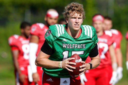 FILE - In this Aug. 9, 2018, file photo, North Carolina State quarterback Ryan Finley runs through a drill during an NCAA college football practice in Raleigh, N.C. Finley returned to school for his final season after flirting with entering the NFL draft and opens the year Saturday against James Madison. (AP Photo/Gerry Broome, File)