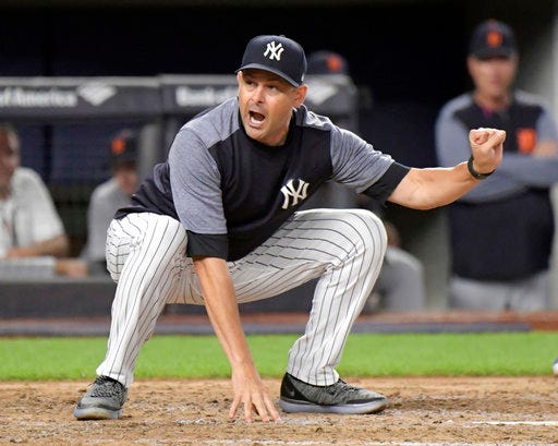 New York Yankees manager Aaron Boone demonstrates to home plate umpire Nic Lentz before being tossed from a baseball game against the Detroit Tigers during the fifth inning Friday, Aug. 31, 2018, at Yankee Stadium in New York. (AP Photo/Bill Kostroun)