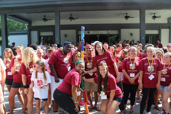 Big Leader Brian Pope holds the top of the spirit stick along with other camp Big Leaders Rebecca Johnson, Lauren Wolfrey, Lauren Parrish, Michael Allen and Meredith Topian at this year's Prince George 4-H Camp. [Contributed Photo]