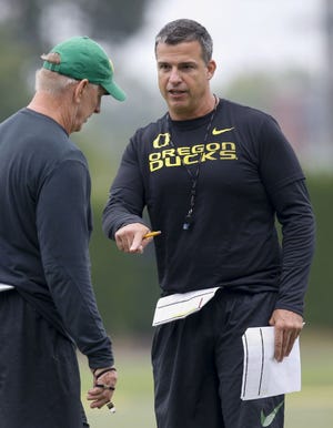 Oregon coach Mario Cristobal (right) talks with defensive coordinator Jim Leavitt talk in practice. The Ducks return seven starters on defense and three others who have started at times in their careers. [Andy Nelson/The Register-Guard]