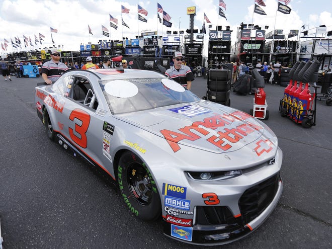 Crew members for Austin Dillon push his car in the garage area before Friday's practice session at Darlington (S.C.) Raceway. The car is painted in a throwback scheme from the Dale Earnhardt era. [The Associated Press]