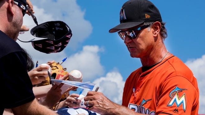 Marlins manager Don Mattingly signs autographs before a spring training game against the Yankees at Roger Dean Chevrolet Stadium in Jupiter on March 11, 2018. (Richard Graulich / The Palm Beach Post)