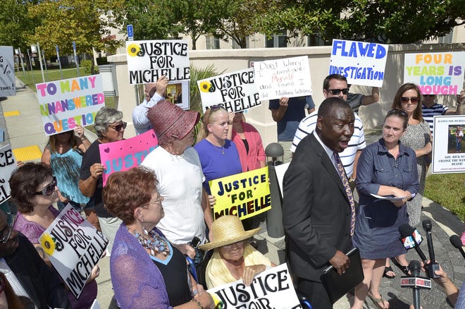 Attorney Benjamin Crump speaks, surrounded by friends and family members of Michelle O'Connell, at a news conference on Sept. 2, 2014, held on the 4th anniversary of her death to call for a new inquiry into her death that was ruled a suicide. [Peter Willott/The Record]