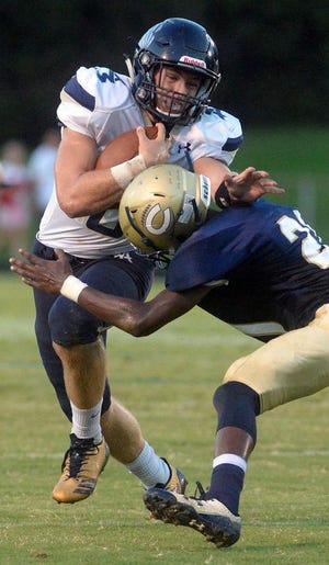 Western Alamance quarterback Bradyn Oakley, left, carries the ball and is tackled by Cummings' Brandon Trollinger.