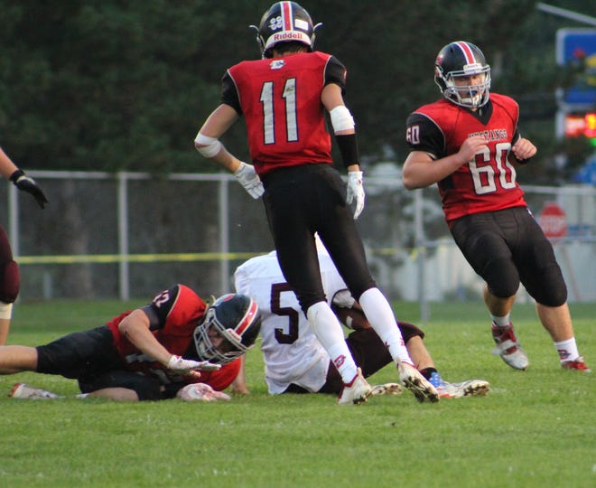 Dansville's Hayden Meyer (72) brings down the ball carrier as Brody Stone (11) and Shane Crandall (60) swarm to the ball in Friday's season-opening home win. [JASMINE WILLIS PHOTOS]