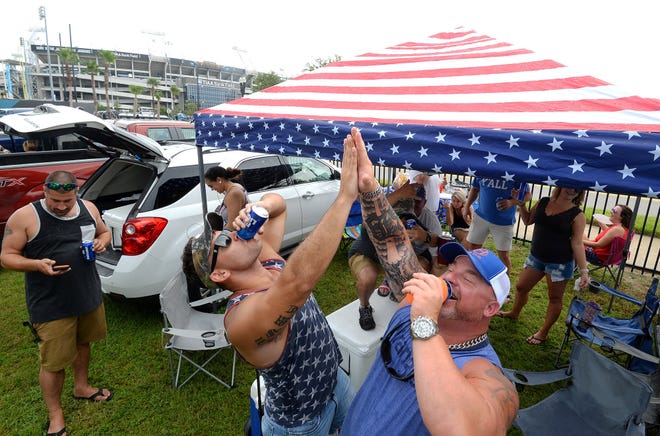 Good friends Cody Cosper of Yulee and Bobby Lott of Hillard chug a beer as they tailgate with friends before the Lynyrd Skynyrd Final Farewell concert at TIAA Bank Field Sunday. (Special/ Dede Smith)