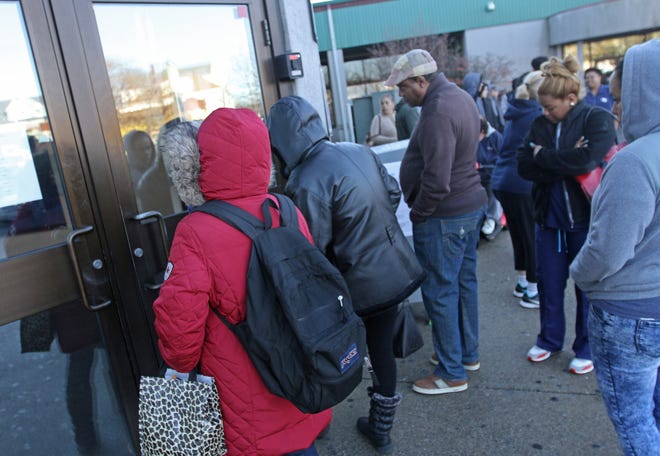 People line up for their social-services benefits at the state Department of Human Services in December 2016. With the state facing major scrutiny over the UHIP debacle, the Department of Administration decided to search for waste and fraud in-house than hire an outside company with a new software product. [The Providence Journal / Steve Szydlowski]