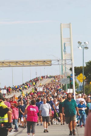 Tens of thousands of people flocked to Mackinaw City Monday morning to walk across the five mile span of the Mackinac Bridge.