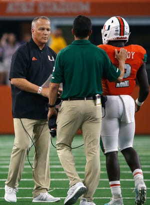 Miami head coach Mark Richt talks with defensive back Trajan Bandy (2) after Bandy was ejected from the game against the LSU on Sunday night. [AP Photo/Ron Jenkins]