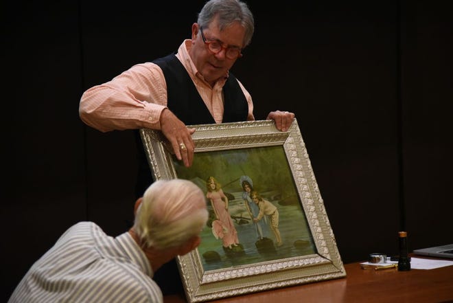 In this Journal Star file photo from 2015, Mark Moran, an antique and fine art appraiser, speaks to Marvin Wilson about his piece of art at the Peoria Public Library North Branch.