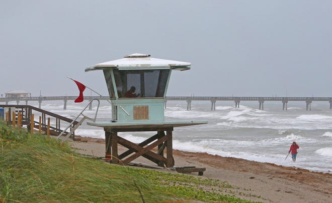 A view of the lifeguard tower while local resident Mike Squillace looking for metal at Dania Beach, Fla., as Tropical Storm Gordon pass by South Florida with wind gust and heavy rainfall for the Labor Day holiday on Monday, Sept. 3, 2018. (David Santiago/Miami Herald via AP)