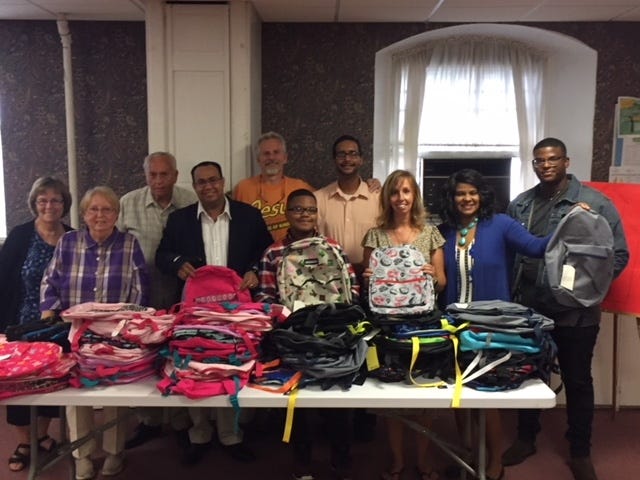 Pilgrim Congregational Church and Spanish Church of God backpack project workers with backpacks Back Row: Lynne McIntyre, Roger Sisson, Pastor Gary Sylvia, Anthony Bacenet Front Row: Charlene Sisson, Pastor Jose Nunez, Eric Nunez, Mel Sylvia, Clomy Bernadeau de Nunez and Joseph Nunez. [Submitted photo]