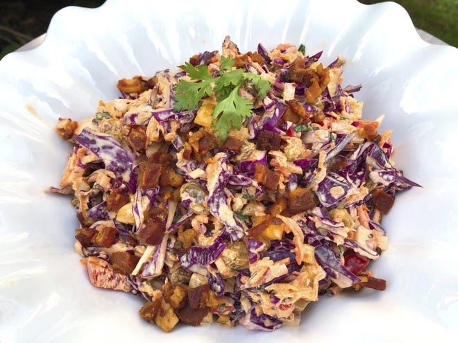 Confetti coleslaw is vibrant and pleasing to the eye, chock full of veggies, and the dressing is spiced with cumin, paprika and cilantro which are perfect companions to ribs with a spice-rub that includes some of the same flavors. (Elizabeth Karmel via AP)