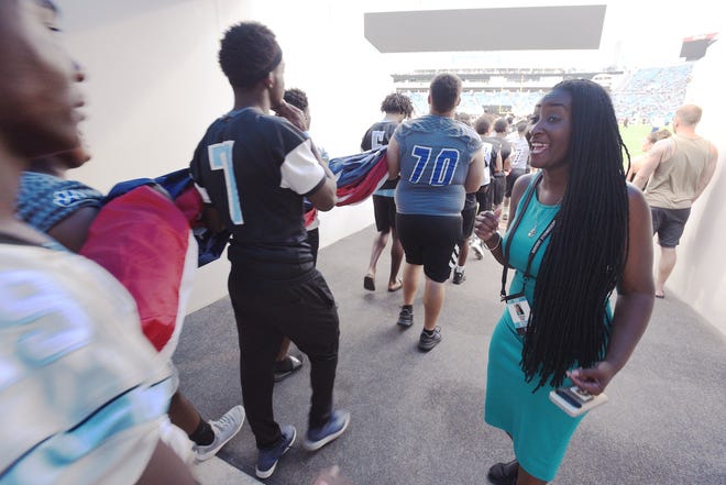T-Neisha Tate, program manager of the Jaguars Foundation, pumps up members of the Ribault and Ridgeview high school football teams as they carry oversized flags onto the TIAA Bank Field for the national anthem before the Jaguars' Aug. 9 preseason game. "Have fun!" she told them. "Pay attention!" [Bob Self/Florida Times-Union]