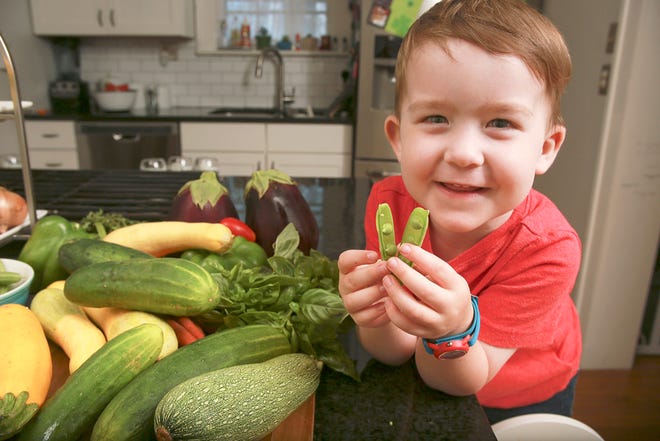 Charles Weaver, 3, samples some produce in his family’s Clintonville home.
