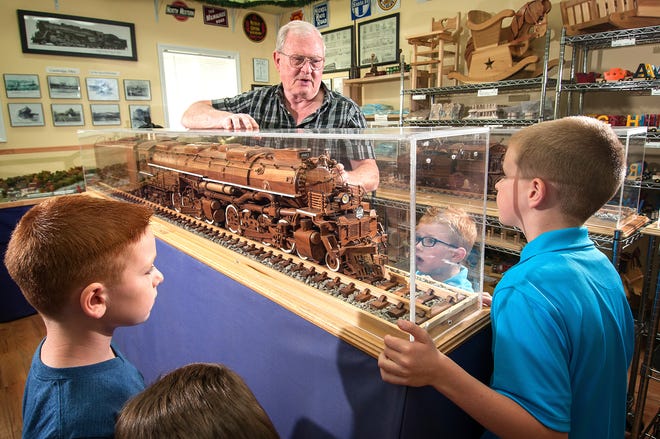 Master Craftsman Brian Gray shares his love for steam locomotives with several young people during their visit to his Cambridge Wooden Toy Company & Great American Steam Locomotive Museum.
