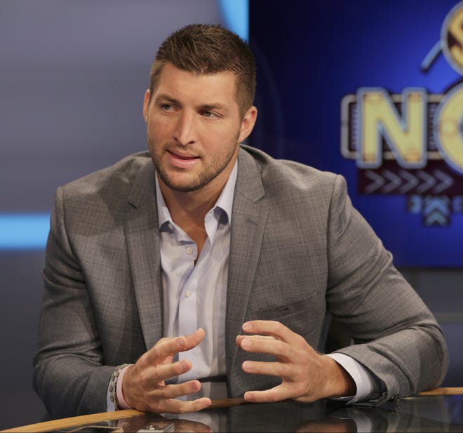 Former Nease High and University of Florida star Tim Tebow answers a question during a interview on the set of ESPN's SEC Network. [AP Photo/Chuck Burton]