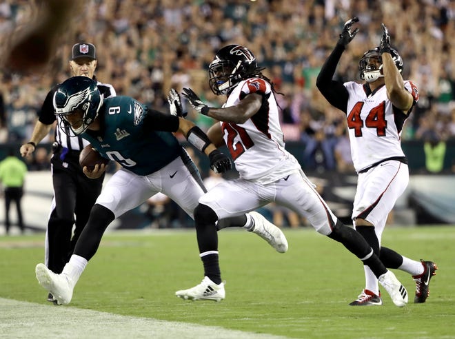 Philadelphia Eagles quarterback Nick Foles (9) is forced out of bounds by Atlanta Falcons defensive back Desmond Trufant (21) and linebacker Vic Beasley (44) after catching a pass during the second half of an NFL football game Thursday, Sept. 6, 2018, in Philadelphia. (AP Photo/Matt Rourke)